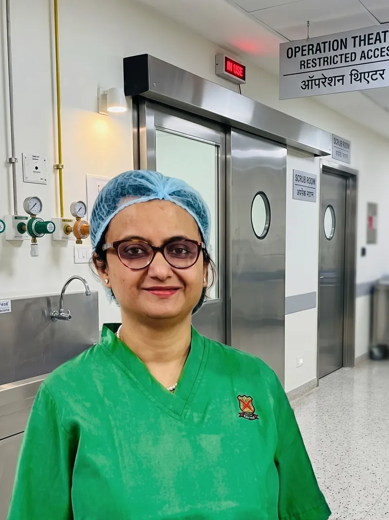 Dr. Dipanwita Banerjee in surgical scrubs and cap outside the operating theatre